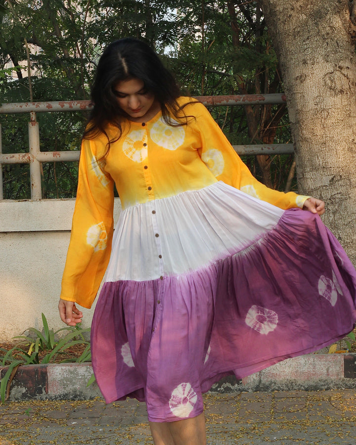 Lilac, yellow, and white bandhani print dress on a model, showcasing the intricate tie and dye design on pure muslin fabric_1