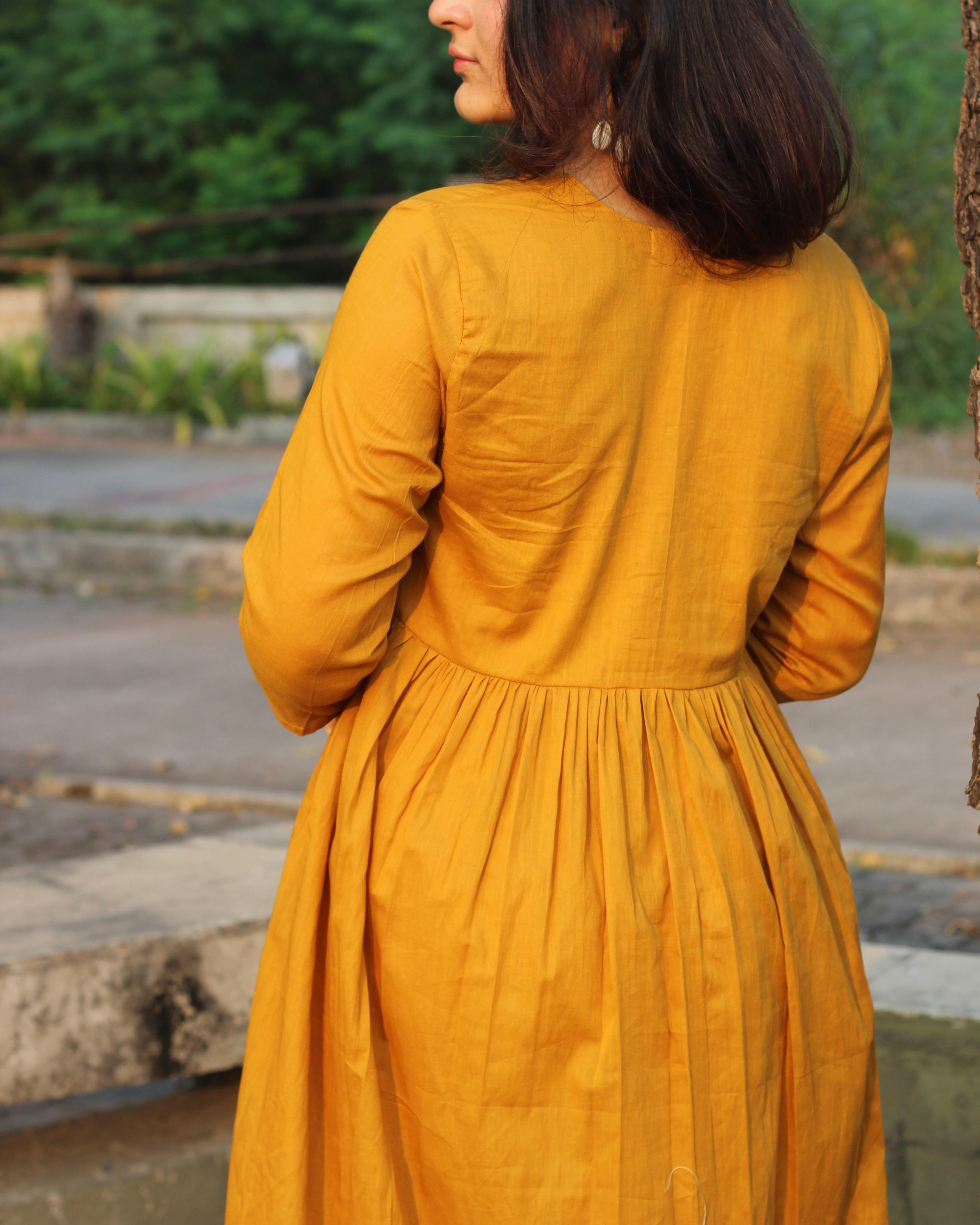 Mustard mul cotton kurta pant set with V-neck, cloth-covered buttons, pleated pattern from yoke, 3/4 sleeves, and pockets, in our best-selling design