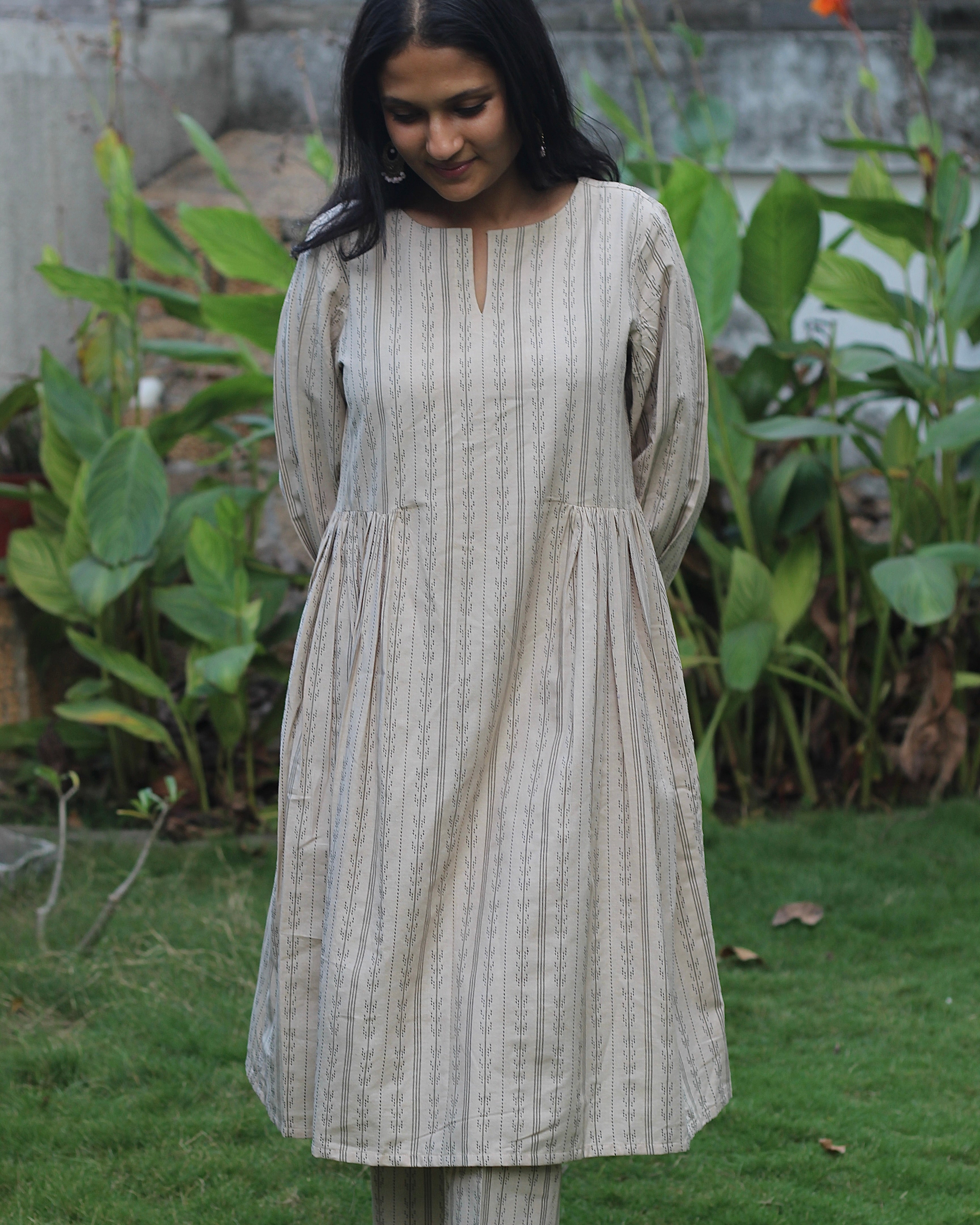 Beige handloom cotton kurta set with stripe pattern, side detail pockets, relaxed neck, and box 3/4 sleeves, paired with elastic waist pants