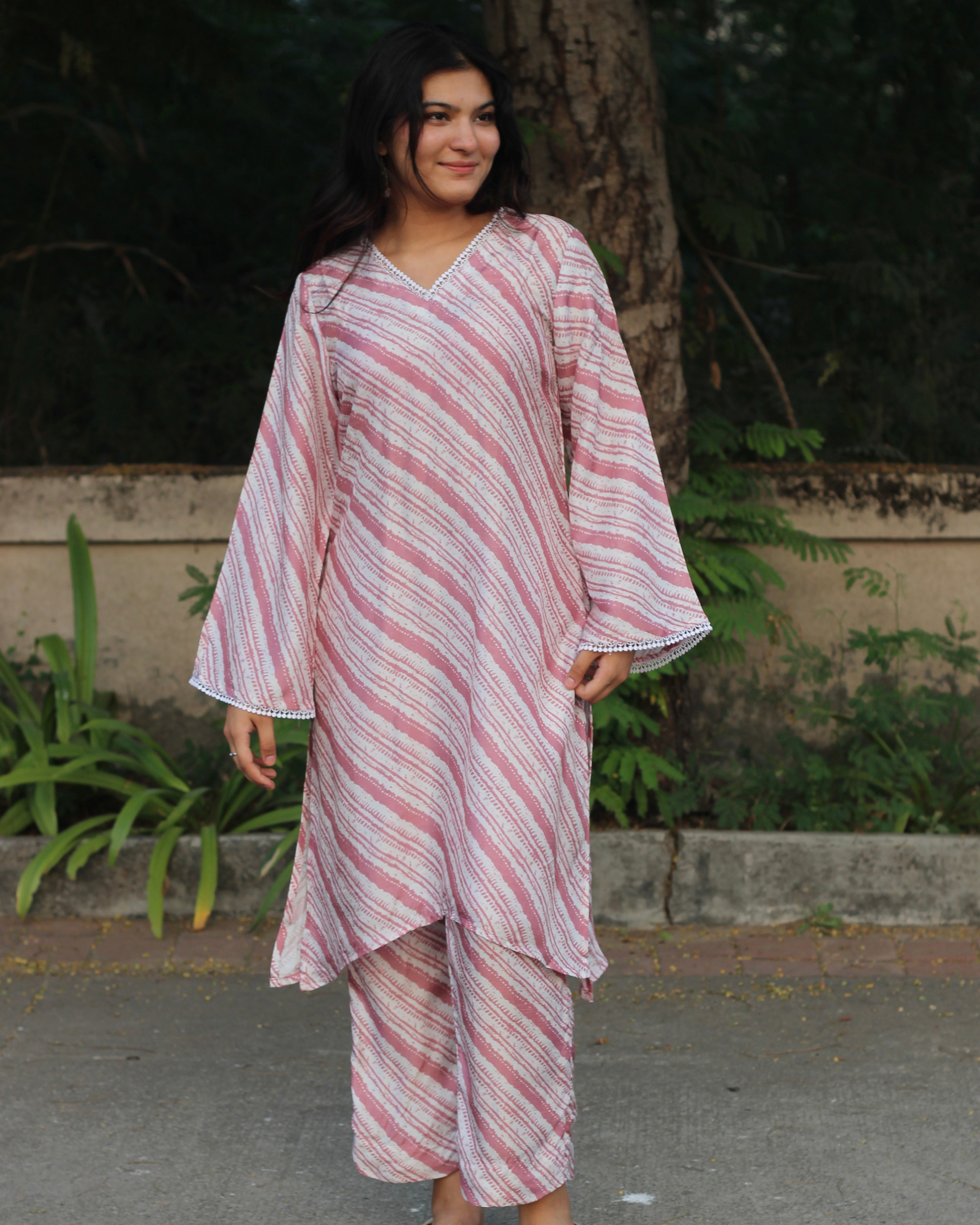 Leheriya print silk kurta set with pink on dull white, featuring V-neck with white lace details, long bell sleeves, and matching pants