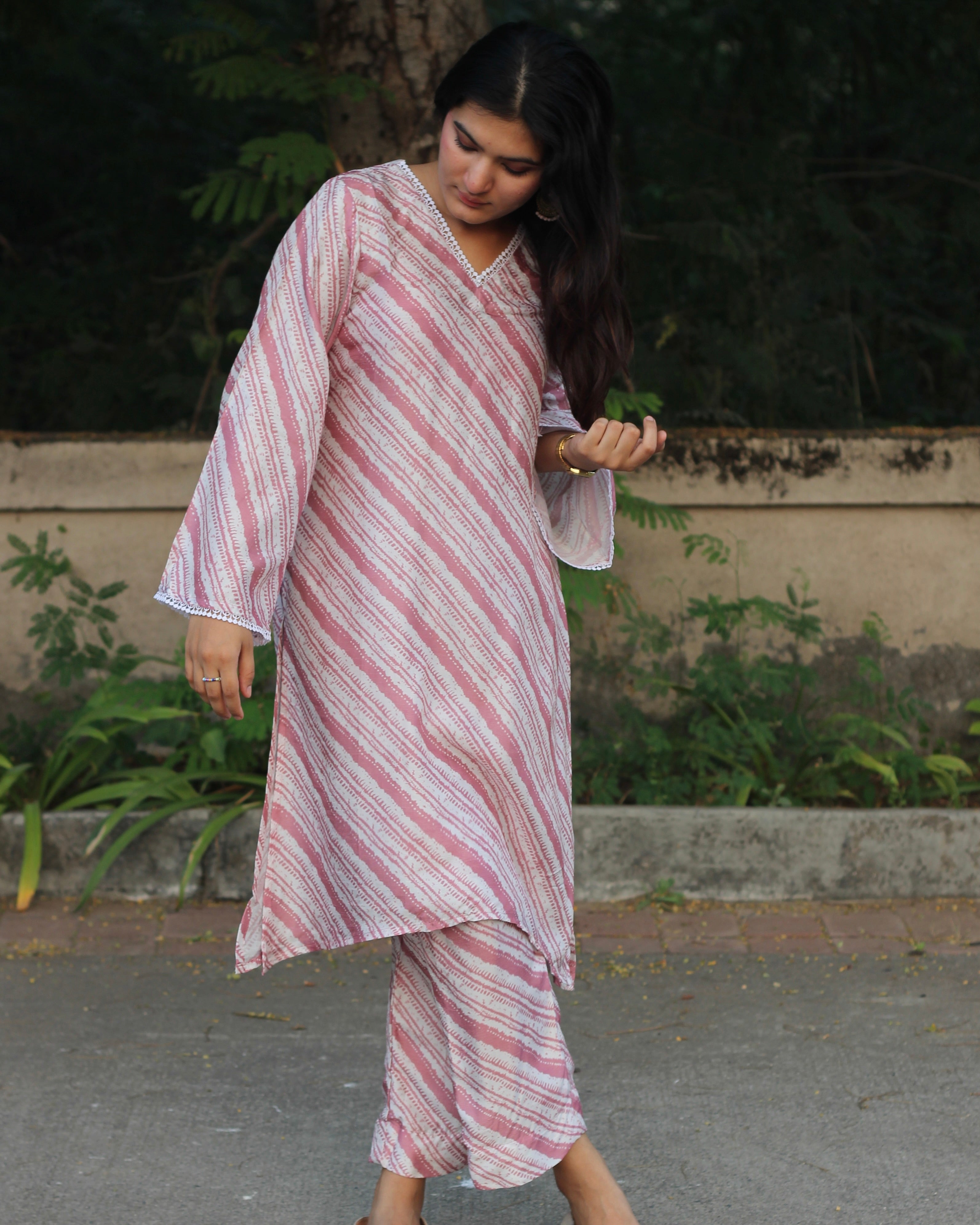 Leheriya print silk kurta set with pink on dull white, featuring V-neck with white lace details, long bell sleeves, and matching pants