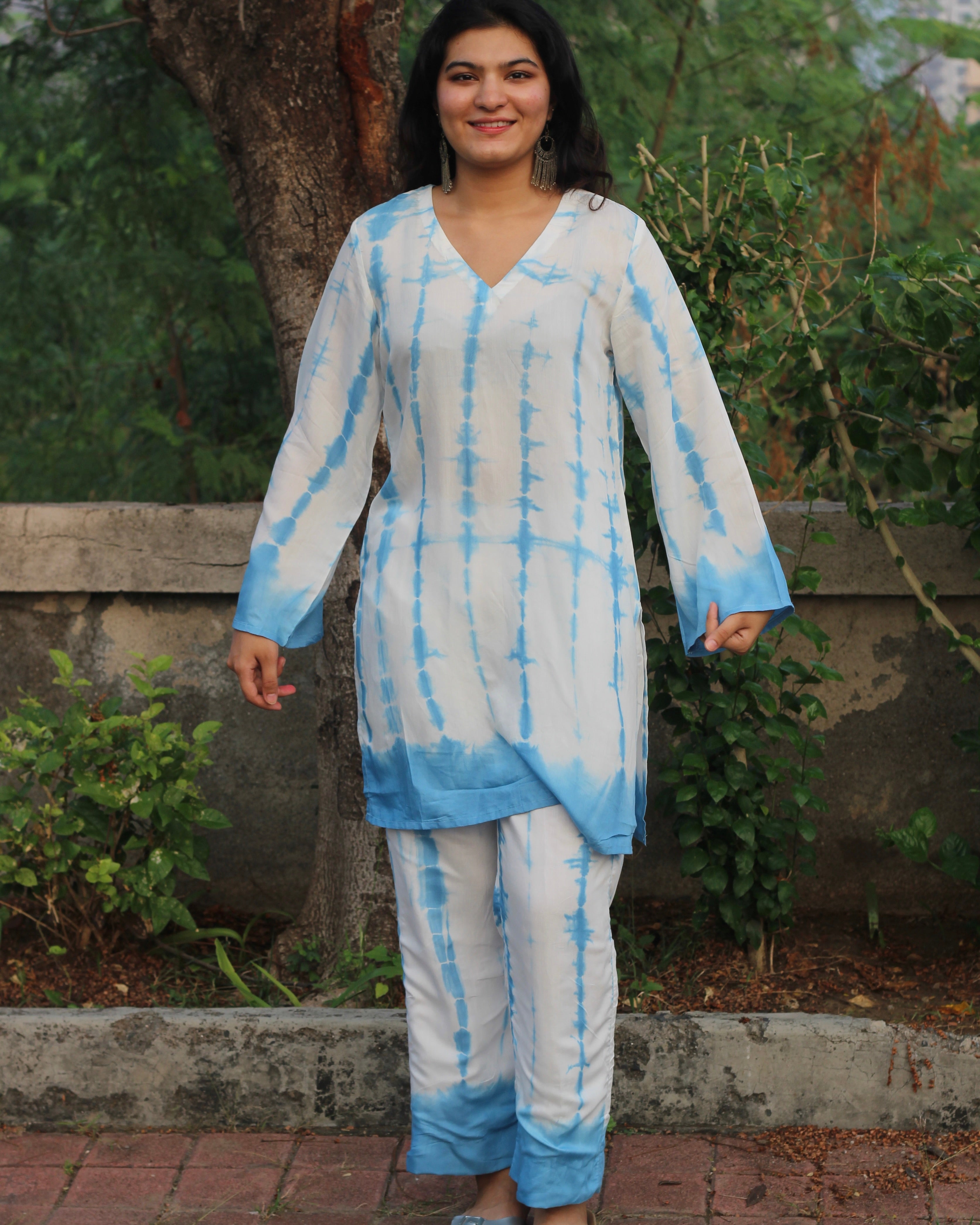 Shibori print muslin co-ord set featuring a knee-length straight kurta with V-neck and bell sleeves, paired with lined pants, in a white and blue palette