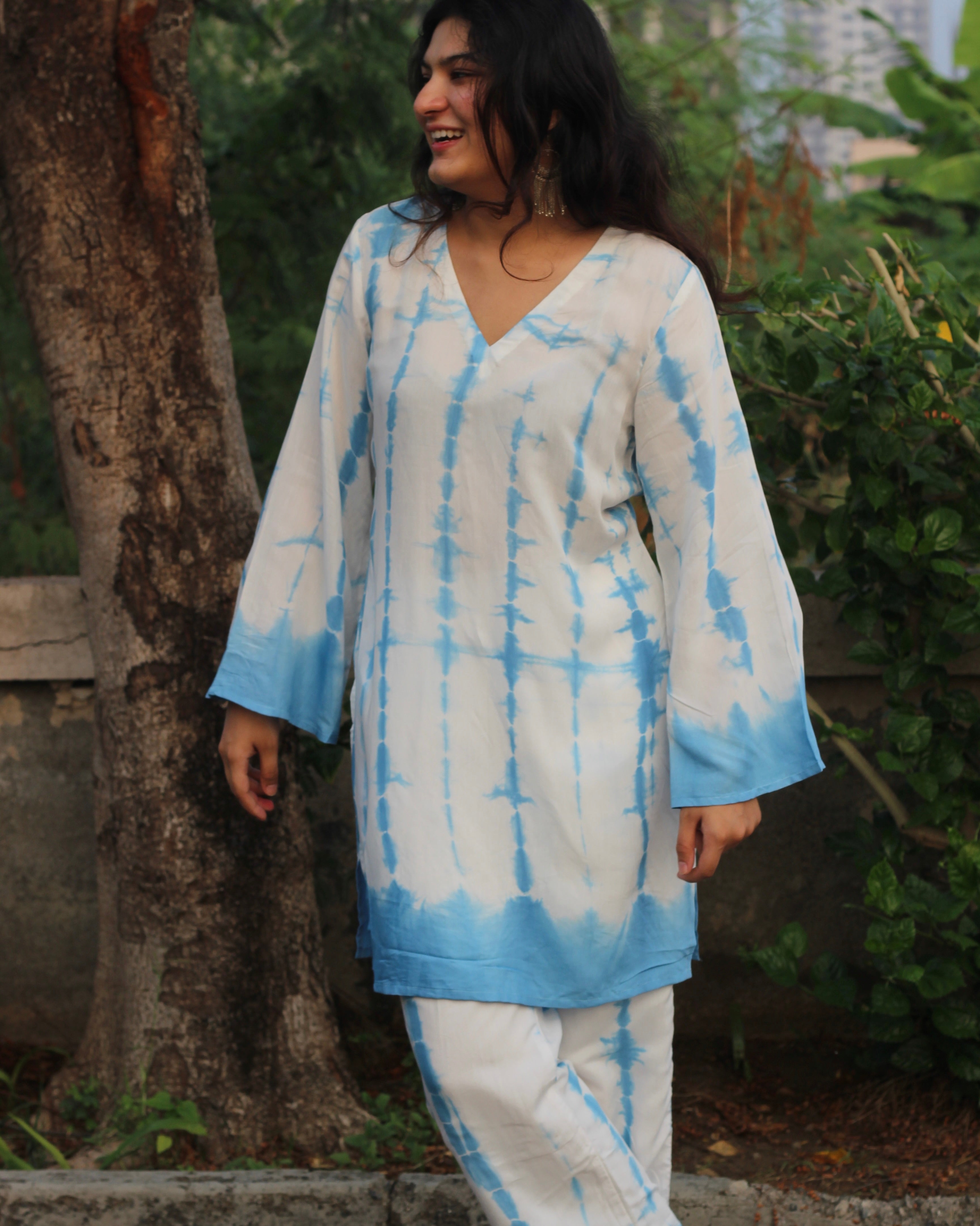 Shibori print muslin co-ord set featuring a knee-length straight kurta with V-neck and bell sleeves, paired with lined pants, in a white and blue palette