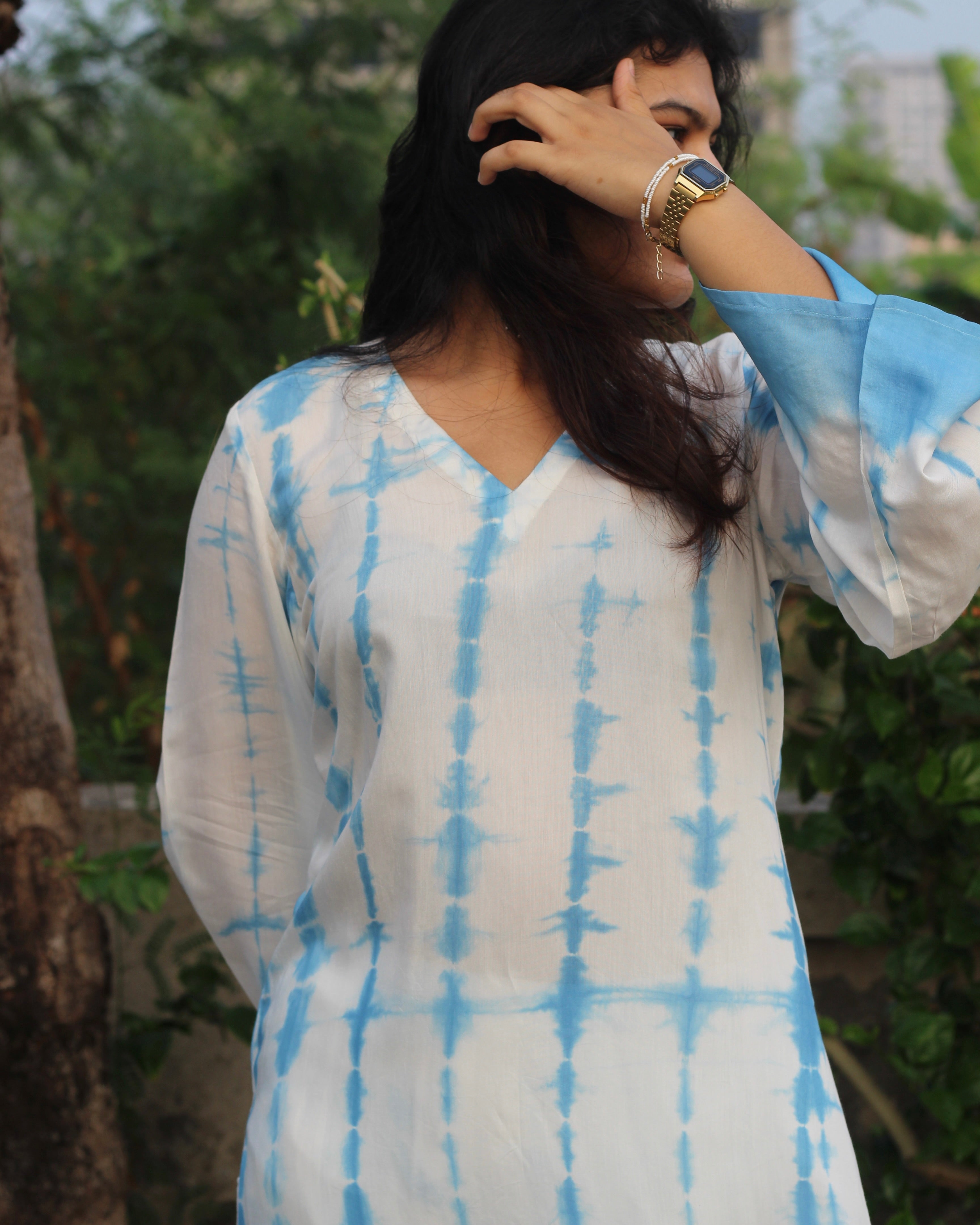 Shibori print muslin co-ord set featuring a knee-length straight kurta with V-neck and bell sleeves, paired with lined pants, in a white and blue palette