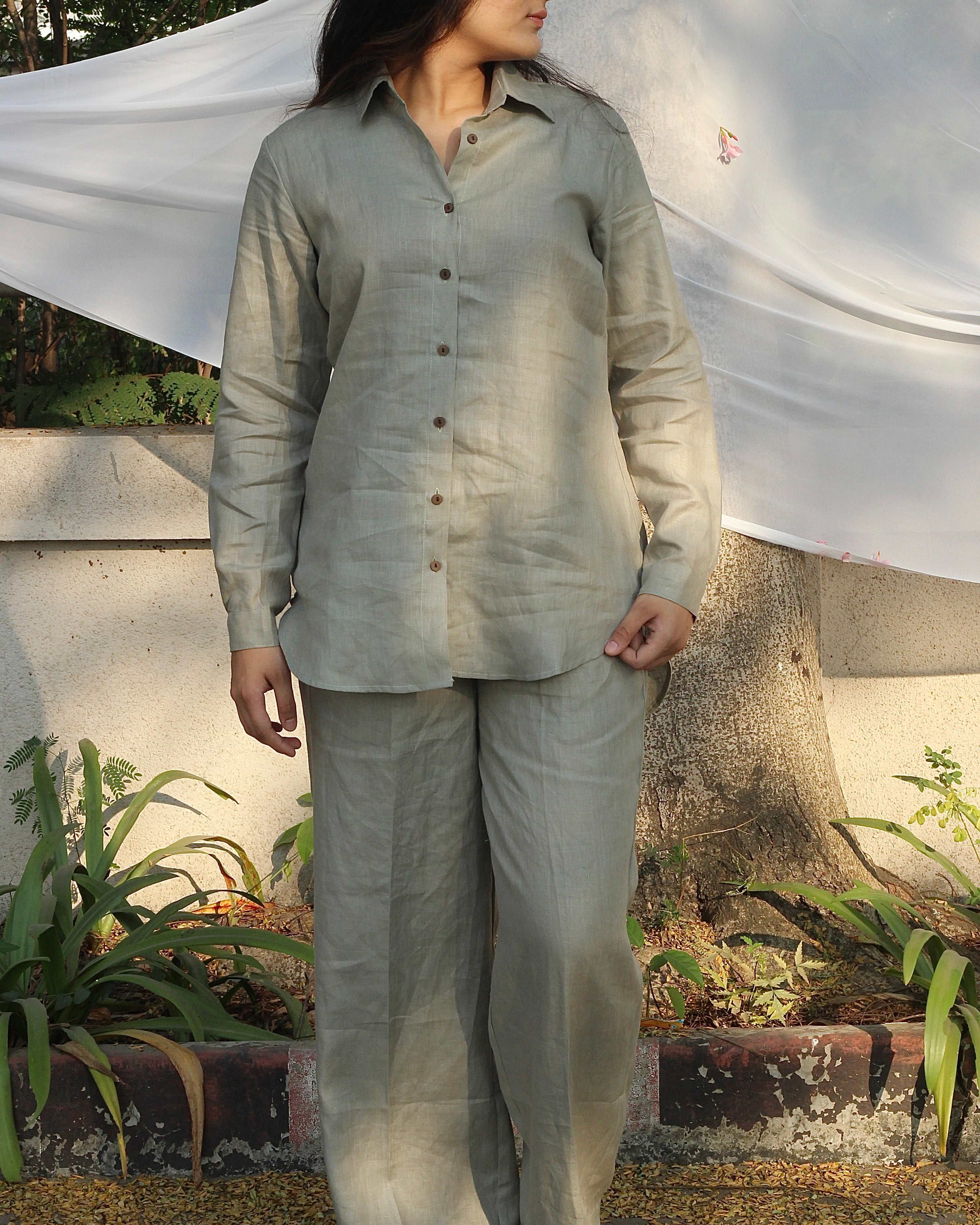 Model wearing a sage green linen co-ord, perfect for an airport look or casual lounging, highlighting its chic and comfortable style