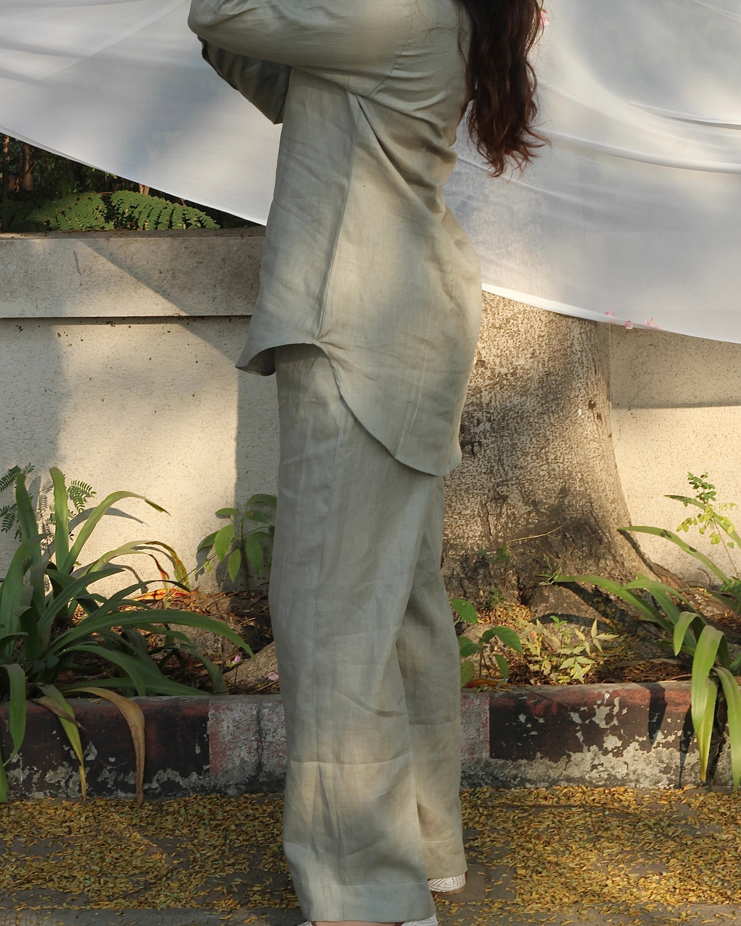 Fashion-forward eco-friendly outfit featuring a sage green linen shirt and wide-legged pants, styled for effortless elegance