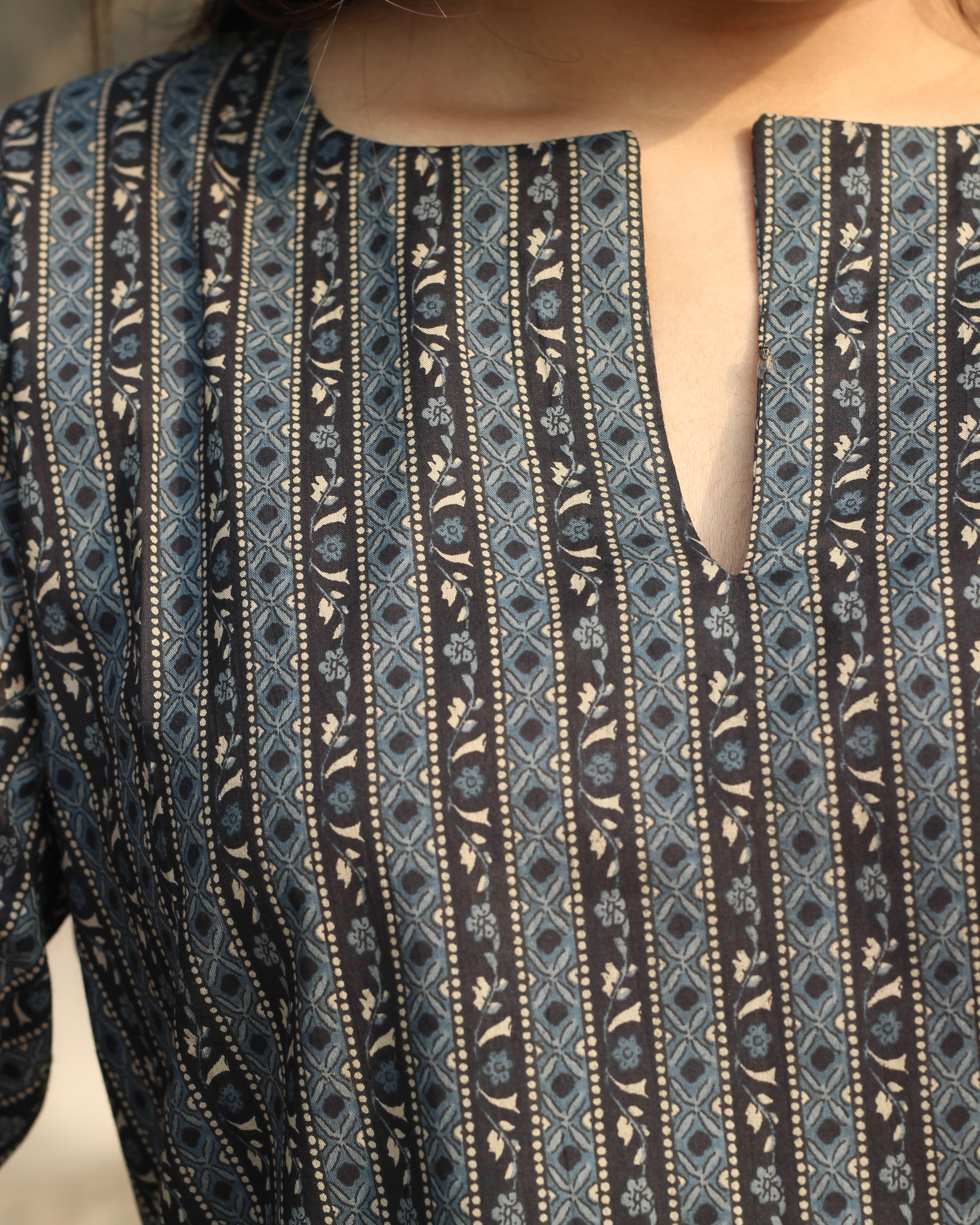 Stripes cotton short kurta in contrasting black and blue shades, with a comfortable round V-neck, 3/4 sleeves, and side cut design