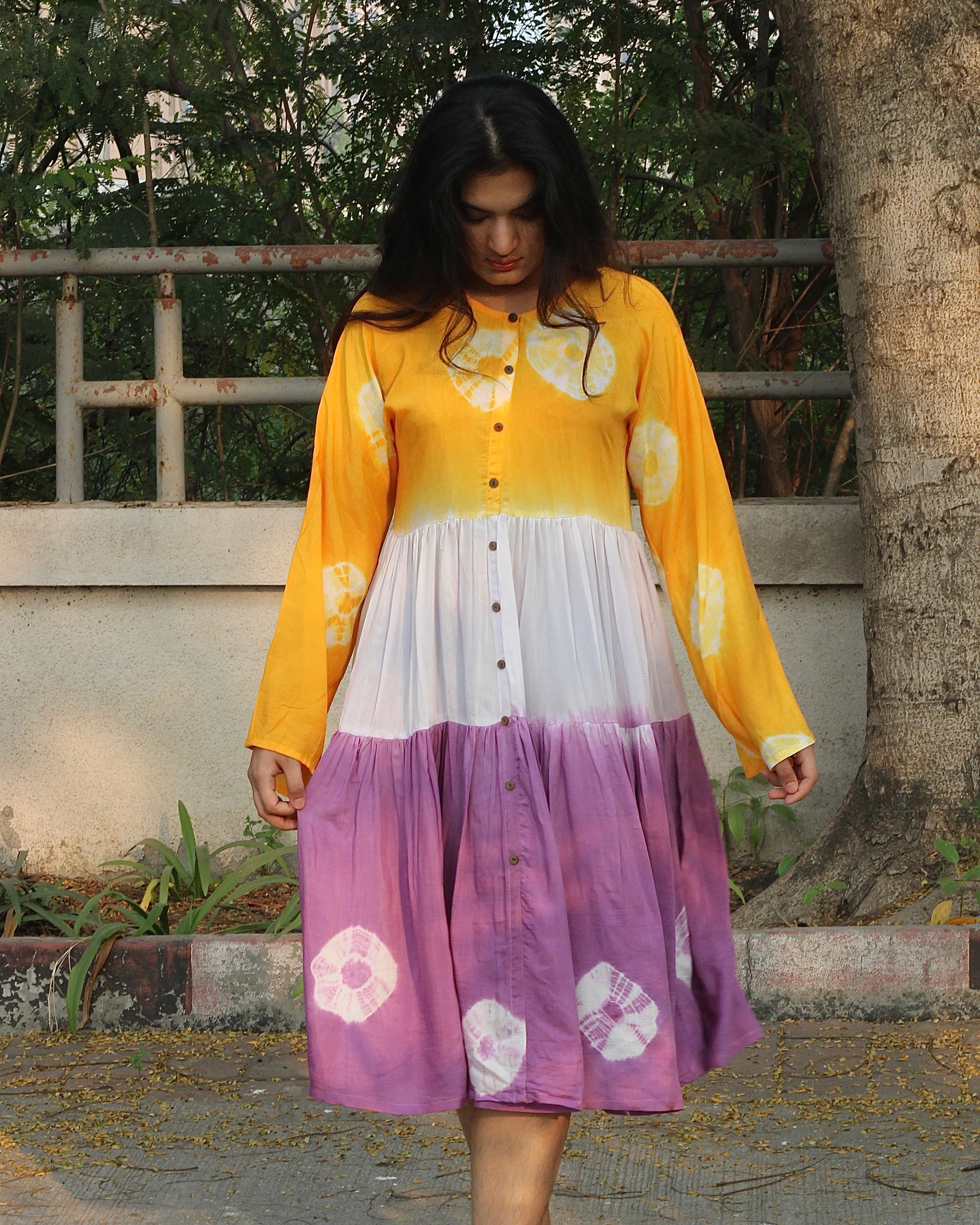 Lilac, yellow, and white bandhani print dress on a model, showcasing the intricate tie and dye design on pure muslin fabric_5