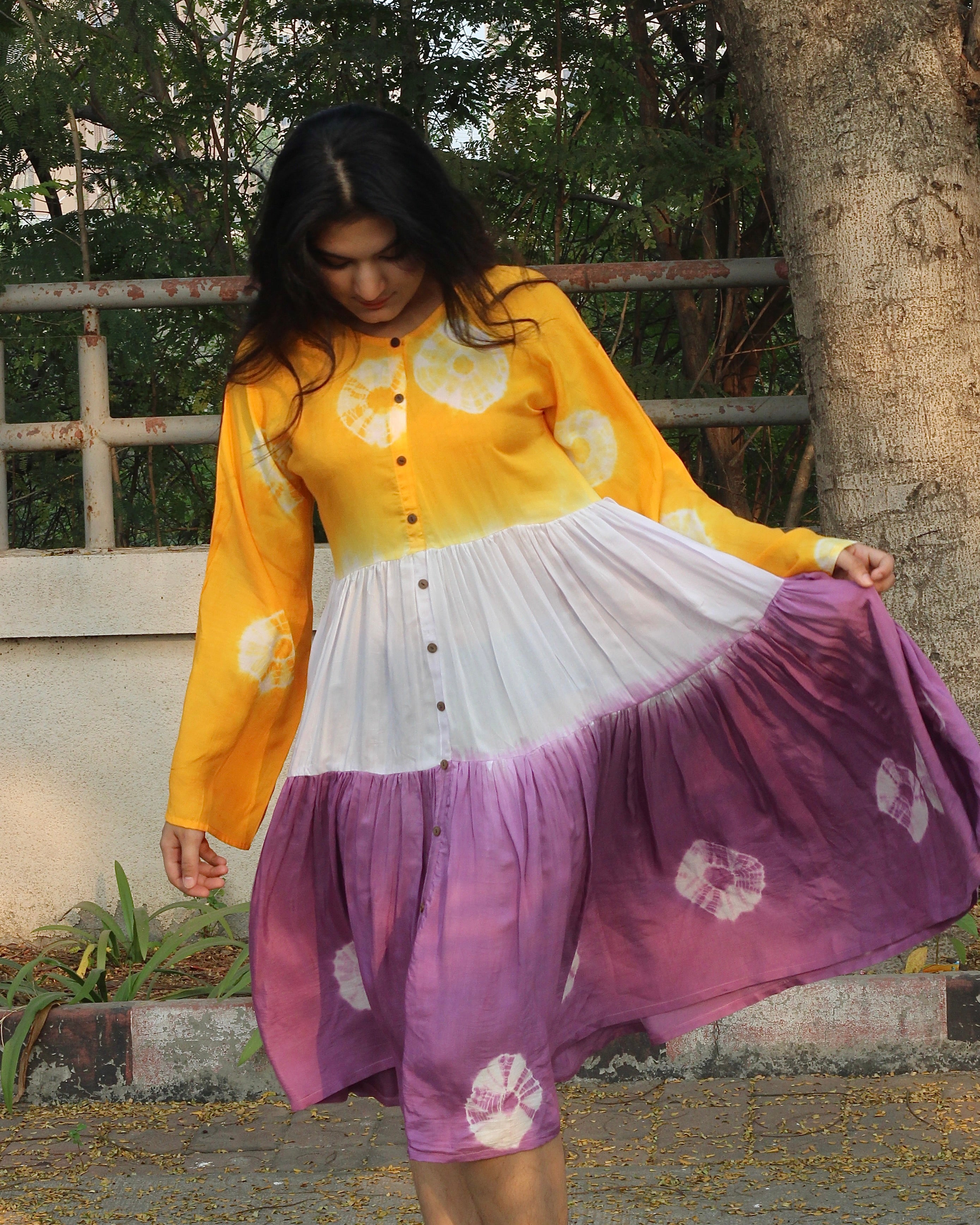 Lilac, yellow, and white bandhani print dress on a model, showcasing the intricate tie and dye design on pure muslin fabric_1