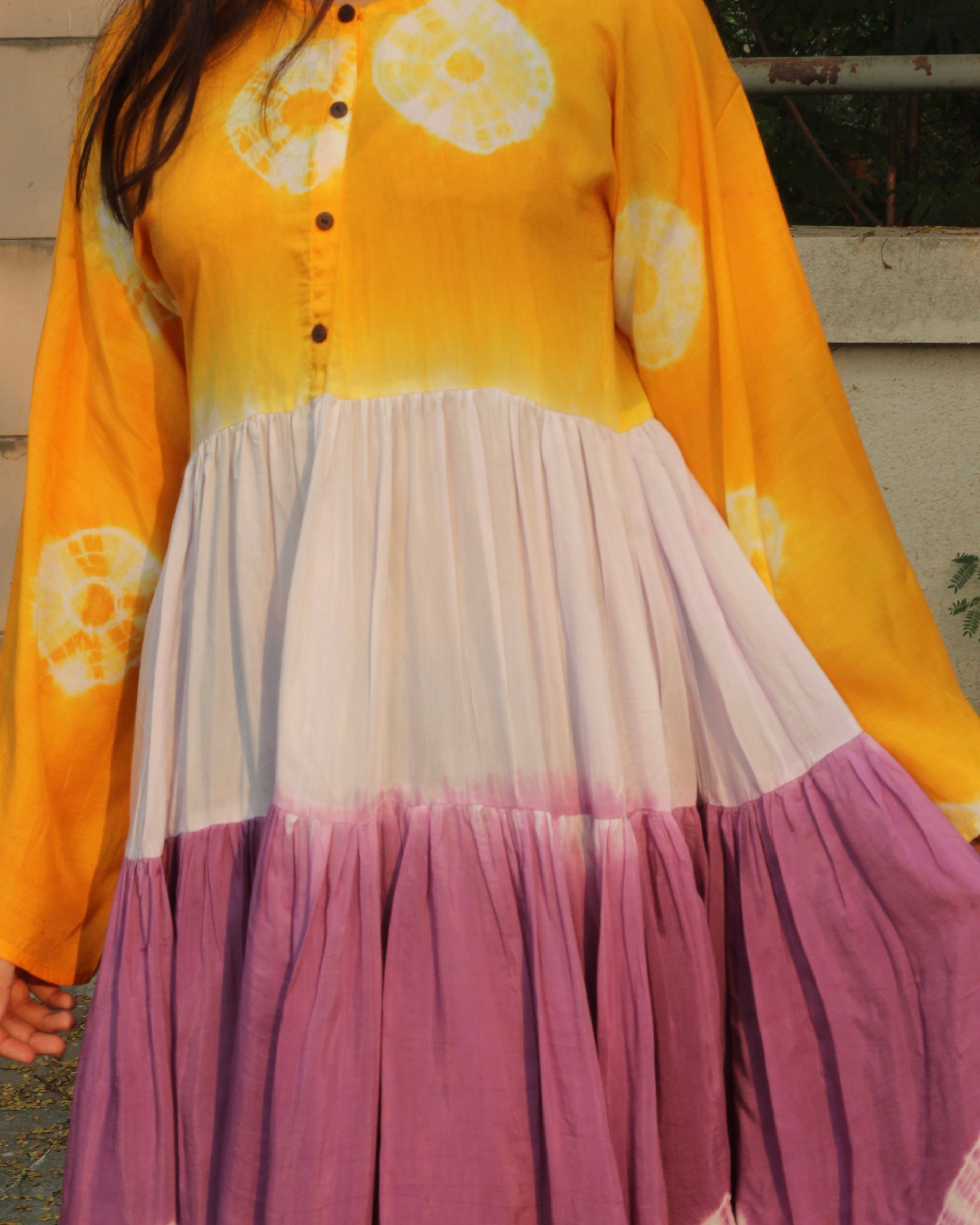 Lilac, yellow, and white bandhani print dress on a model, showcasing the intricate tie and dye design on pure muslin fabric_3