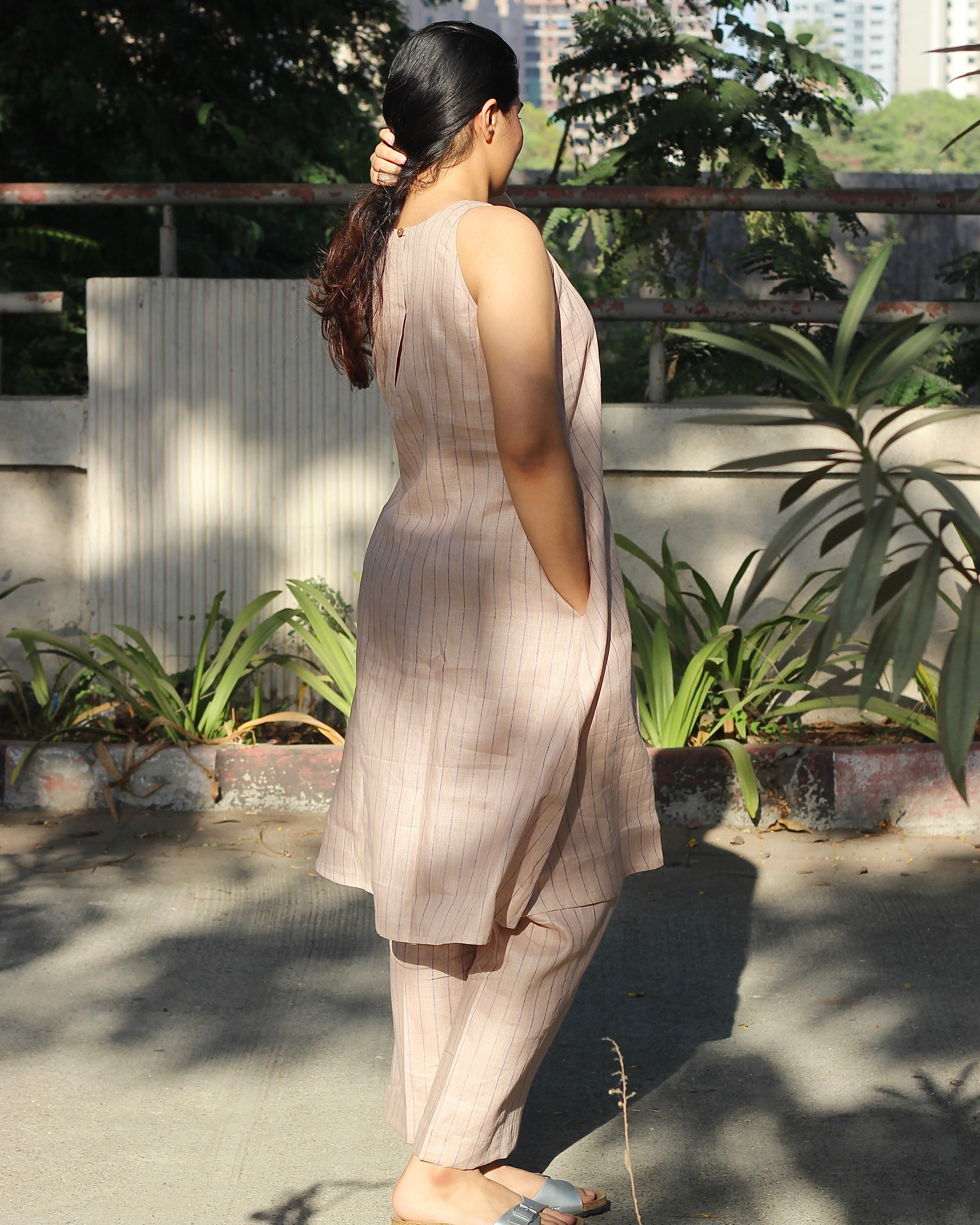 Sleeveless top and ankle-length pants in premium dusty pink linen with delicate light black stripes, featuring a unique long back loop detail