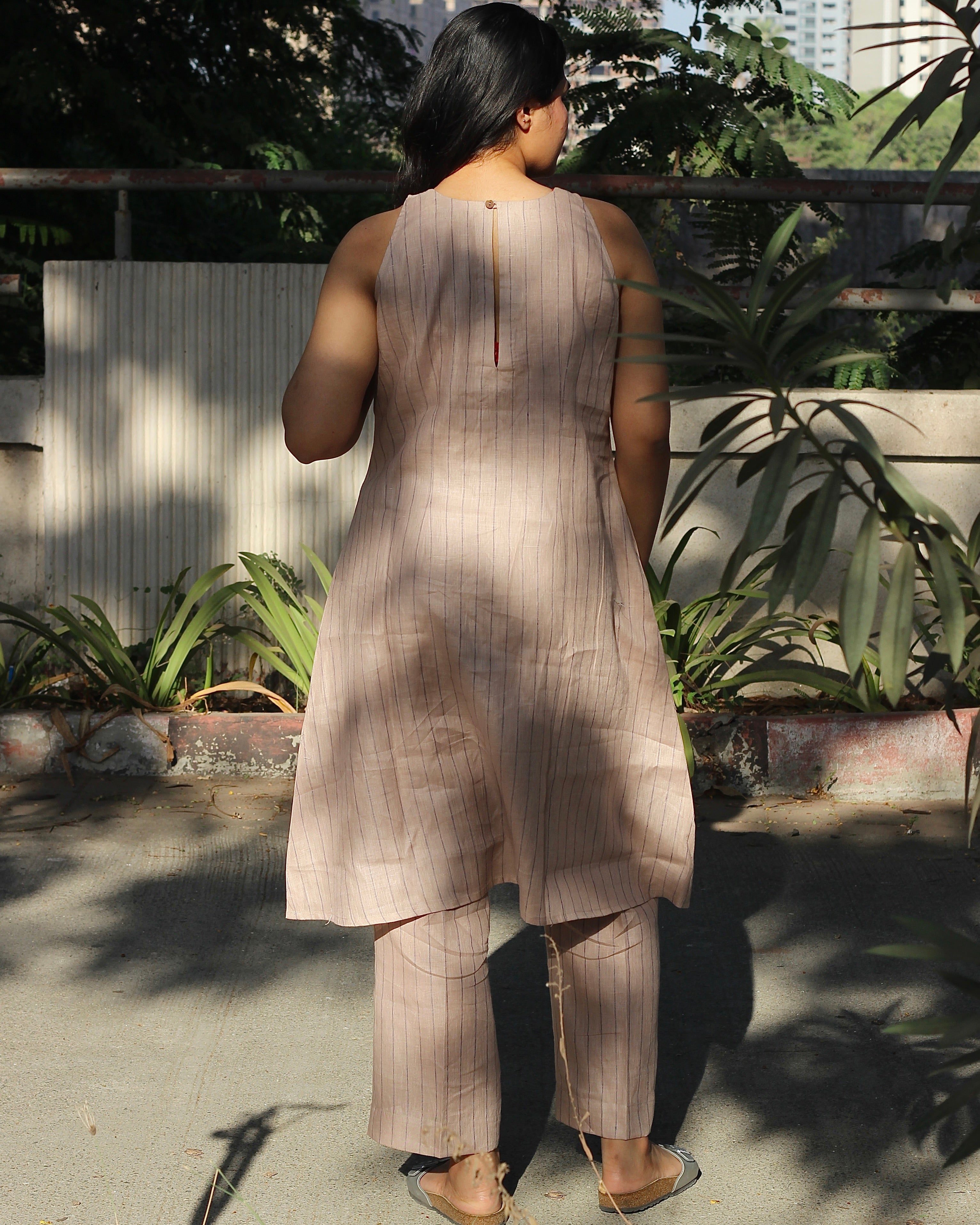 Sleeveless top and ankle-length pants in premium dusty pink linen with delicate light black stripes, featuring a unique long back loop detail
