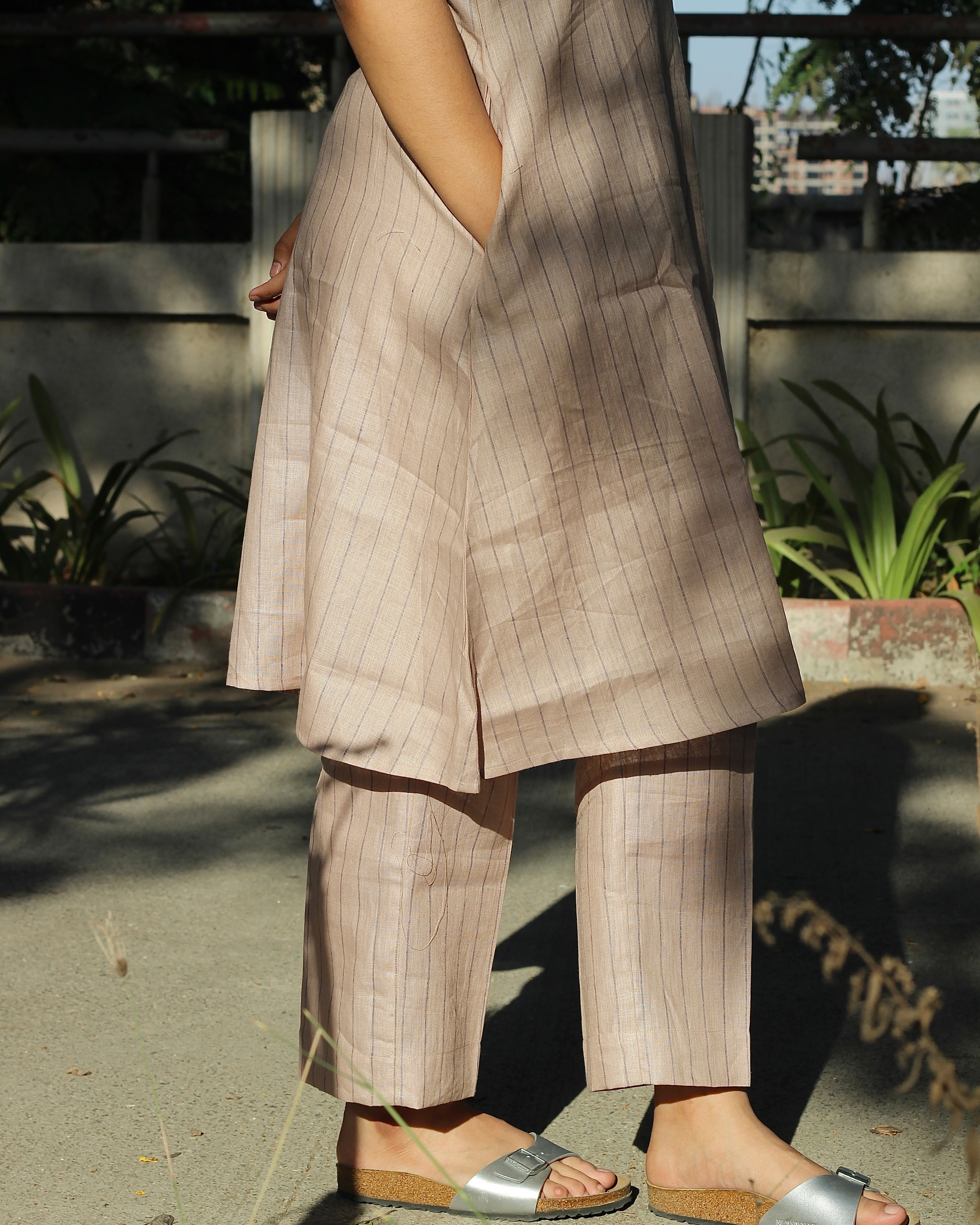 Sleeveless top and ankle-length pants in premium dusty pink linen with delicate light black stripes, featuring a unique long back loop detail