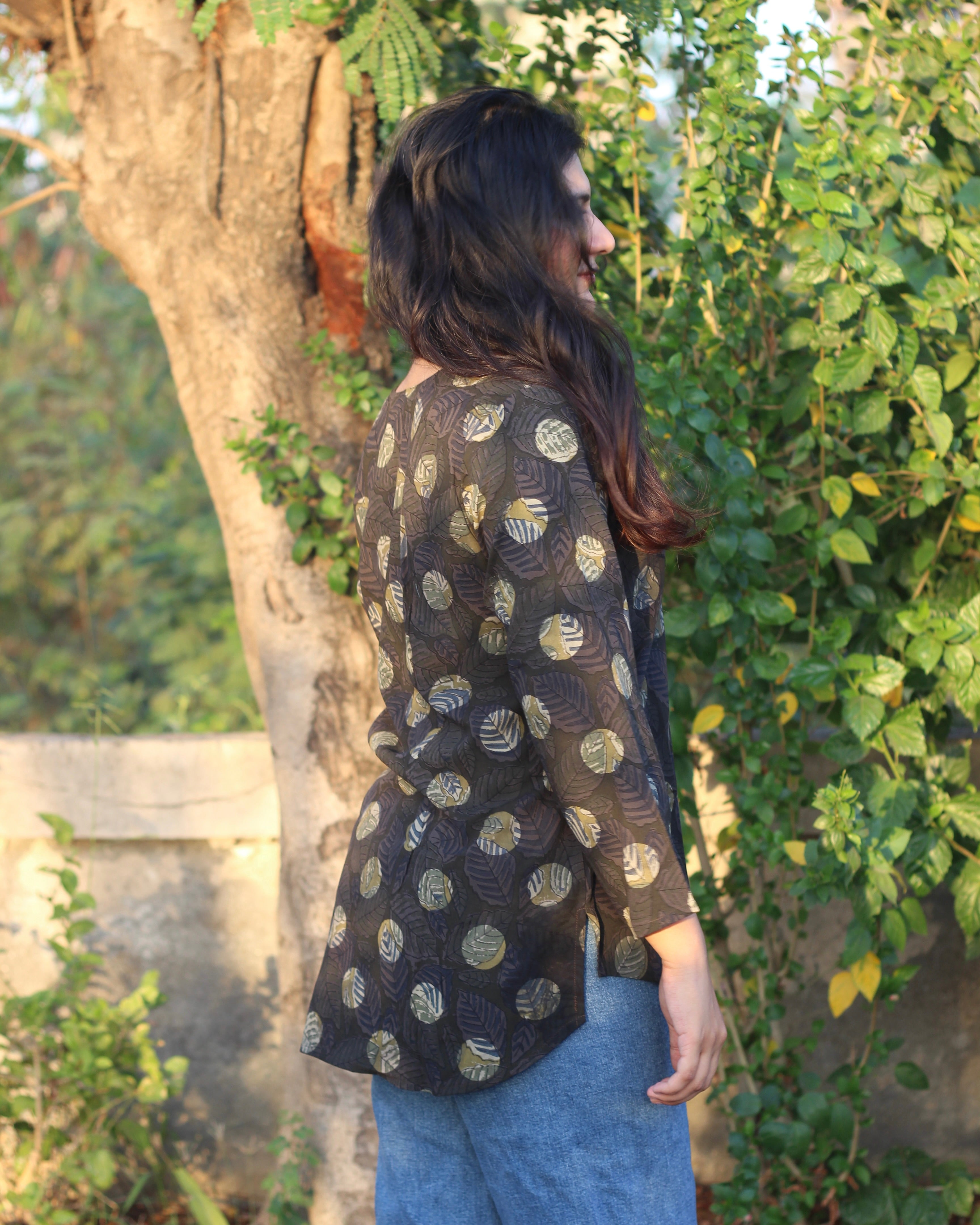 Stylish brown printed short kurta with dark contrasting lead print, featuring a V-neck, 3/4 sleeves, and small side cuts for a chic look