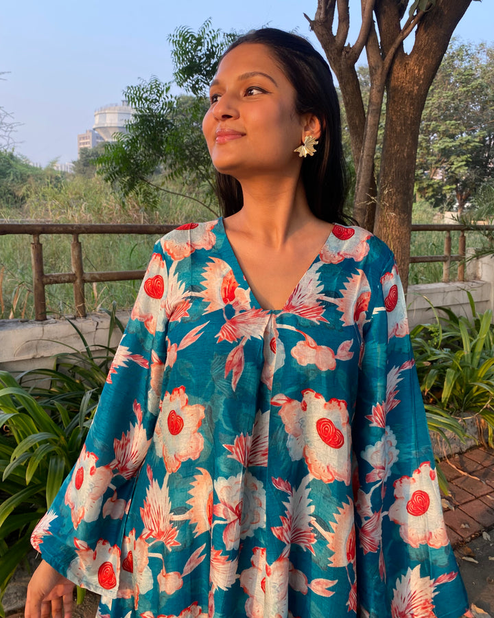 Bright teal floral silk kurta set with big white and red florals, unique V-neck with box pattern, and full bell sleeves for a chic summer look