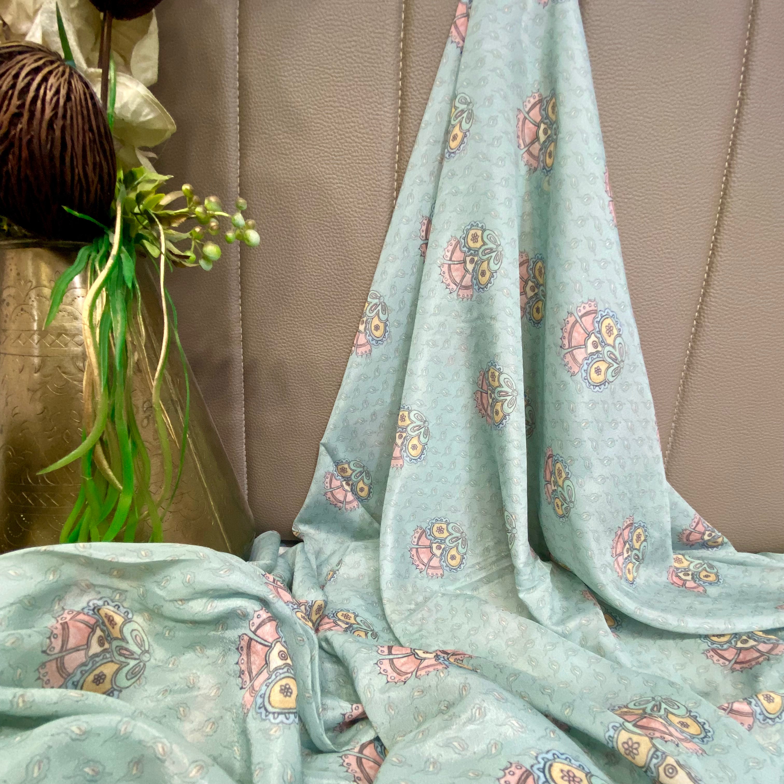 Sky Blue fabric with a colourful floral design and traditional motifs per meter