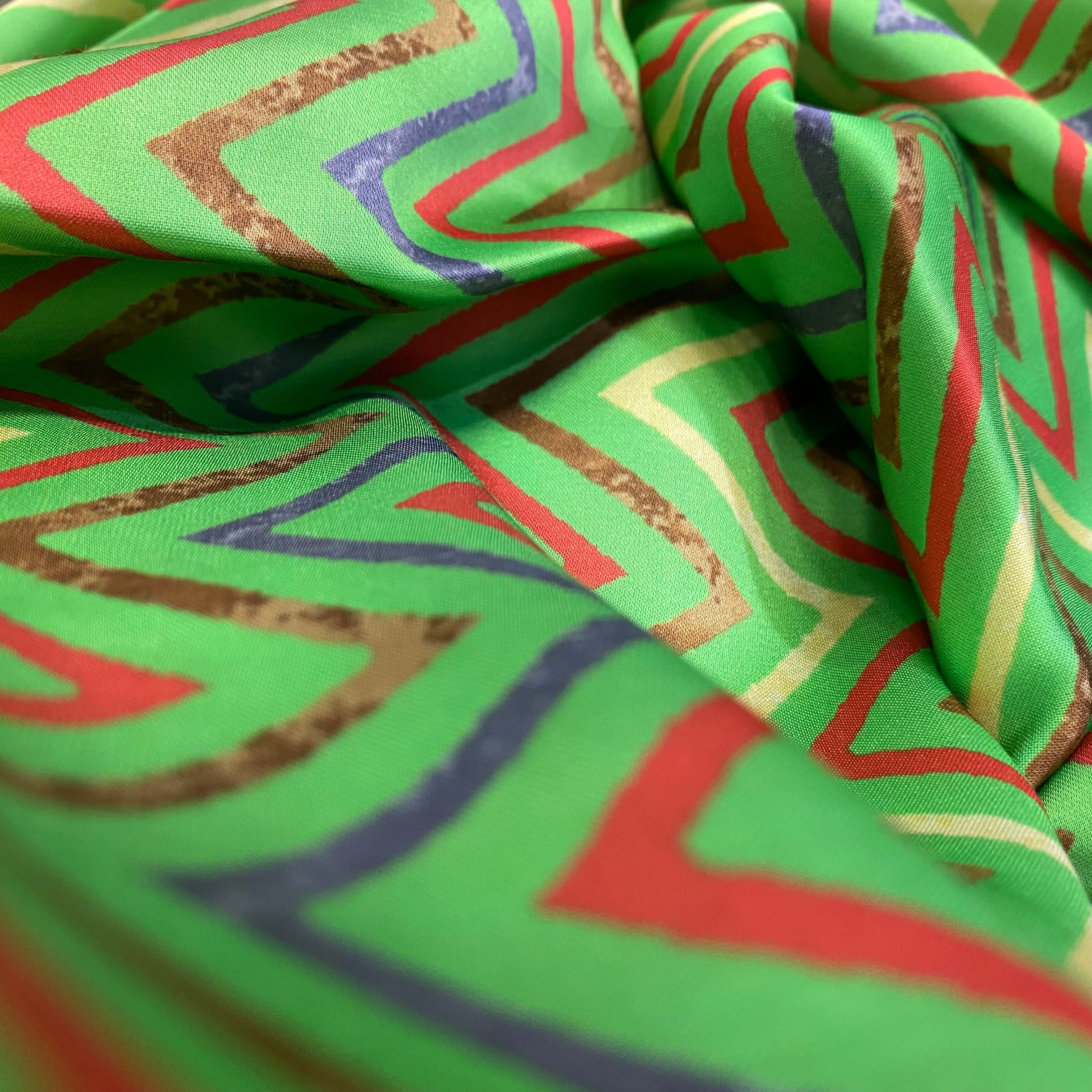 Green top and bottom with multicoloured floral pattern on top and zigzag bottom, per meter price
